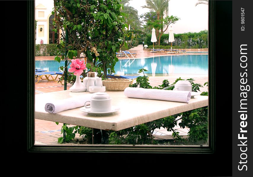 Covered little table at the Italian restaurant visible from a window