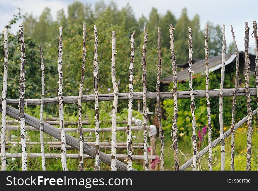 Old fence and kitchen garden behind it. Old fence and kitchen garden behind it