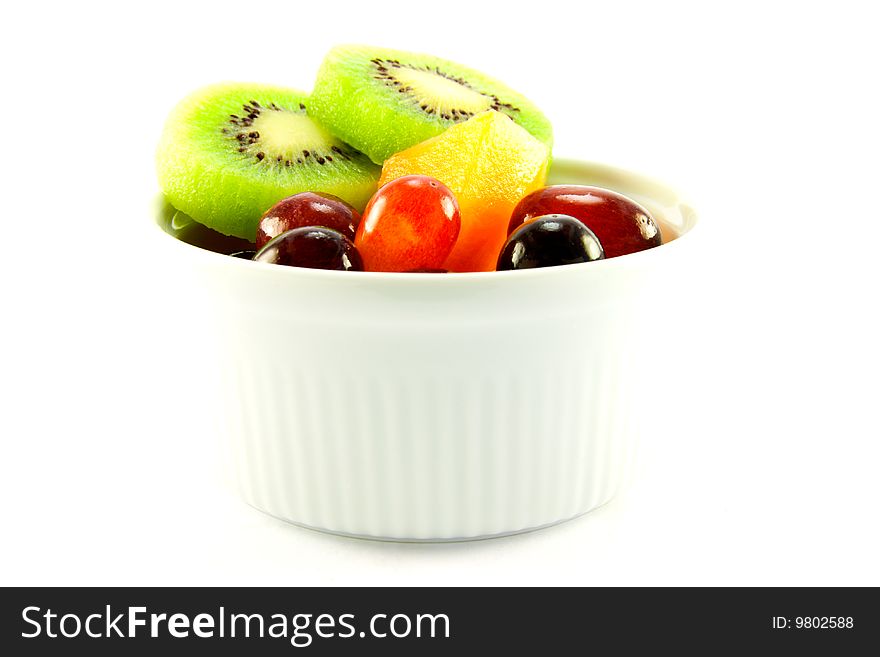 Pot of fruit including kiwi, melon and grapes with clipping path on a white background. Pot of fruit including kiwi, melon and grapes with clipping path on a white background