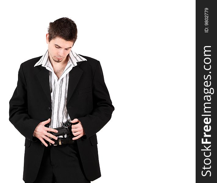 Portrait of young male bodyguard looking at gun in pants, studio shot. Portrait of young male bodyguard looking at gun in pants, studio shot