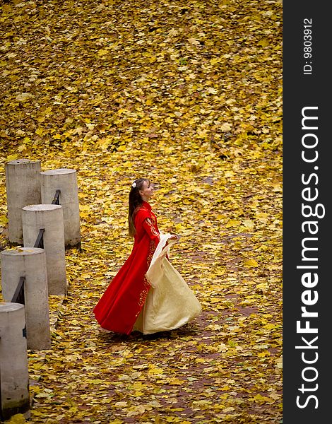 Lady in medieval red dress in the autumn forest. Lady in medieval red dress in the autumn forest