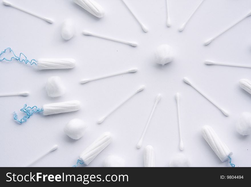 A pattern of arranged female sanitary items, including tampons, cotton wool and cotton buds. The pattern is in a circular design, similar to a sun. A pattern of arranged female sanitary items, including tampons, cotton wool and cotton buds. The pattern is in a circular design, similar to a sun.