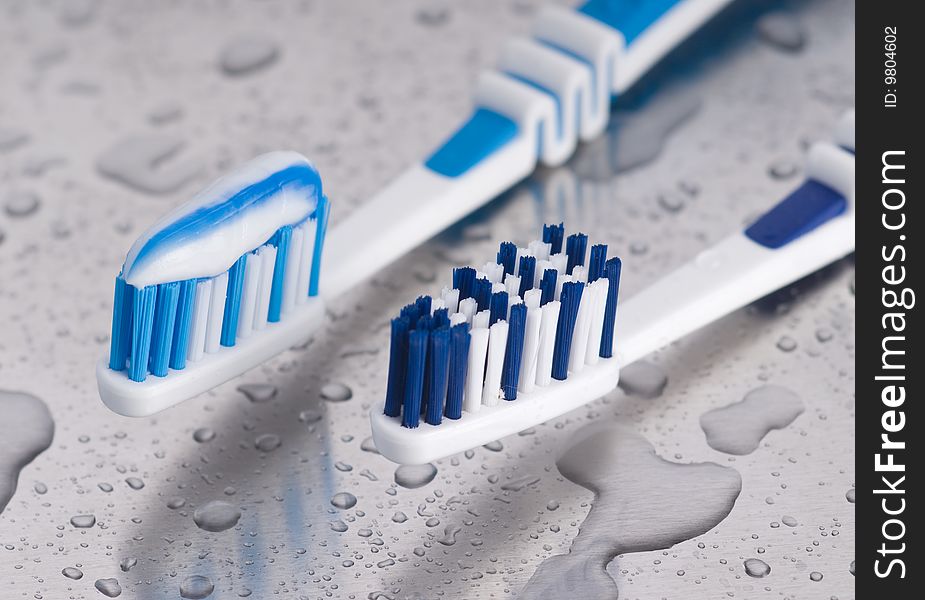 Two tooth brushes on wet surface