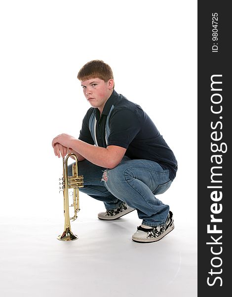 Teenage boy leaning on his upright trumpet