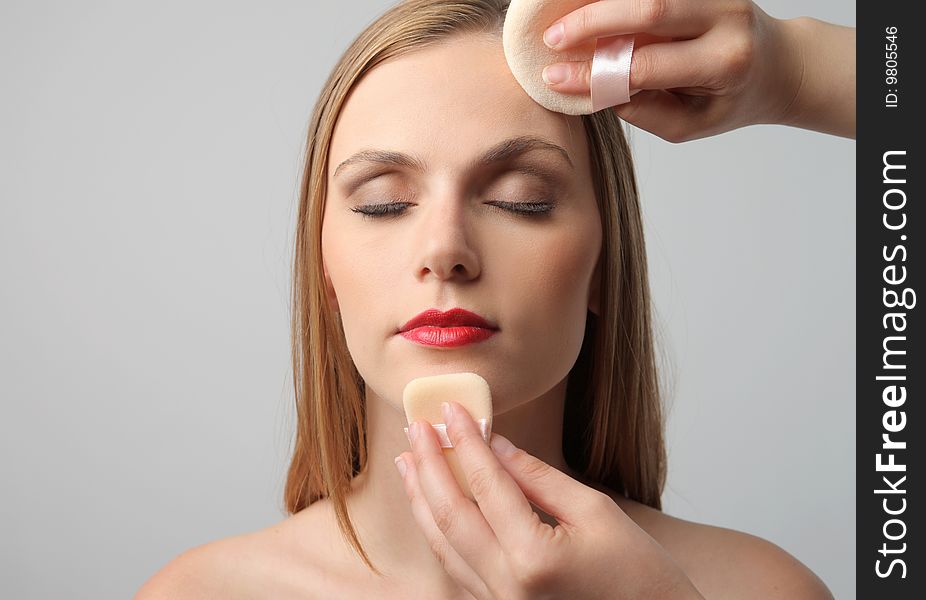 Makeup artist hands cleaning the face of a model