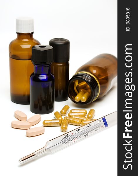 Essential oil bottles, capsules, pills and a thermometer. Essential oil bottles, capsules, pills and a thermometer.