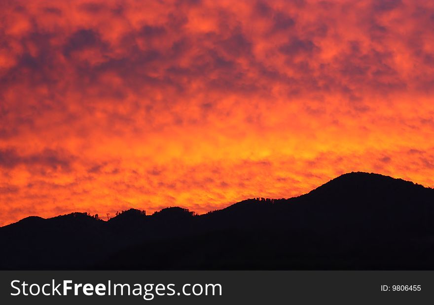 Rising sun and silhouette of mountains