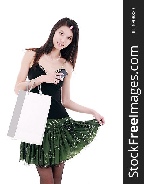 A beautiful Asian girl holds a shopping bag on white background. A beautiful Asian girl holds a shopping bag on white background.