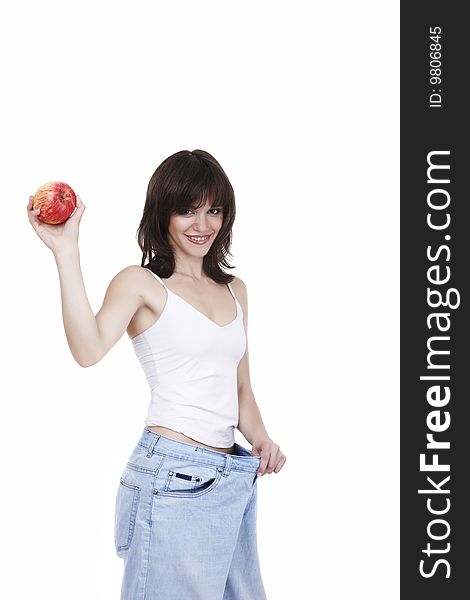 The beautiful girl in jeans of the big size holds a red apple in a hand. The beautiful girl in jeans of the big size holds a red apple in a hand
