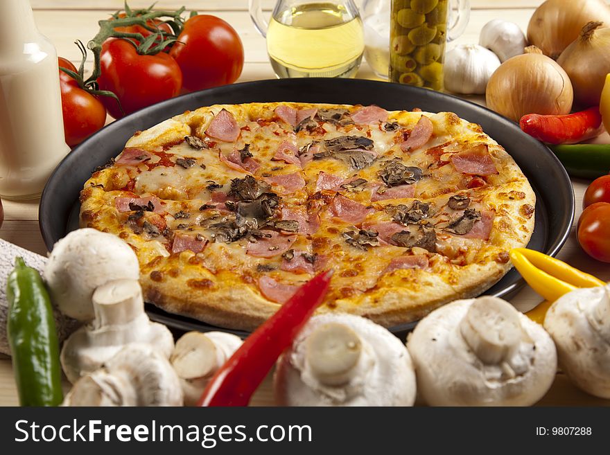 A couple of delicious pizzas, with raw tomatoes, green peppers and mushrooms. A couple of delicious pizzas, with raw tomatoes, green peppers and mushrooms