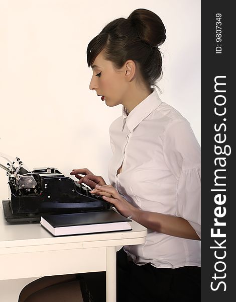 Secretary working with vintage typewriter, shot in studio. Secretary working with vintage typewriter, shot in studio
