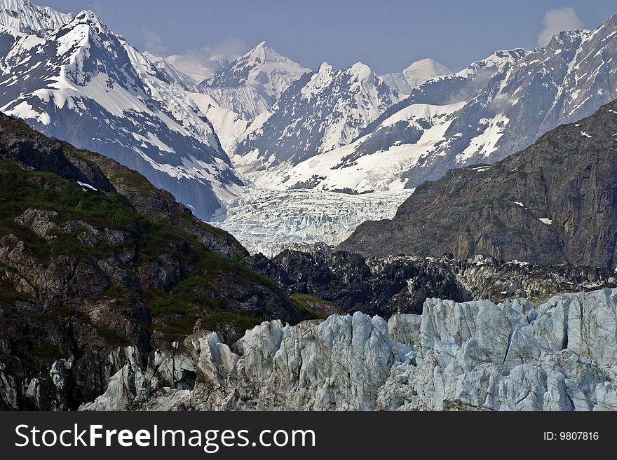 Marge Glacier in Glacier Bay, Alaska flowing from the high mountain range in the background all the way to the blue ice of the foreground. Marge Glacier in Glacier Bay, Alaska flowing from the high mountain range in the background all the way to the blue ice of the foreground