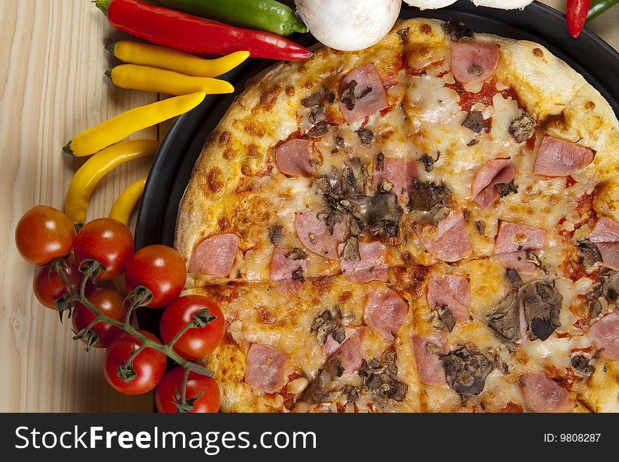 A couple of delicious pizzas, with raw tomatoes, green peppers and mushrooms. A couple of delicious pizzas, with raw tomatoes, green peppers and mushrooms