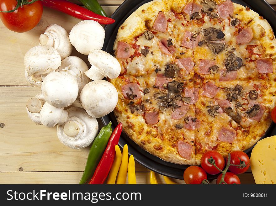 A couple of delicious pizzas, with raw tomatoes, green peppers and mushrooms. A couple of delicious pizzas, with raw tomatoes, green peppers and mushrooms