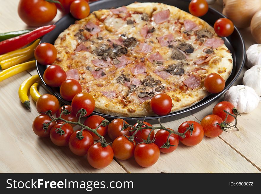 A couple of delicious pizzas, with raw tomatoes, green peppers and mushrooms. A couple of delicious pizzas, with raw tomatoes, green peppers and mushrooms