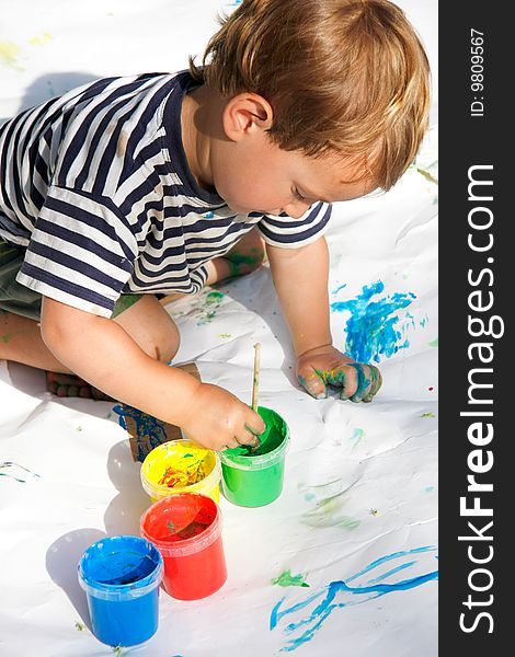 Young boy painting over white