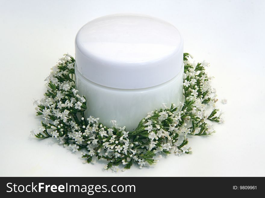 Little white cream jar with flower