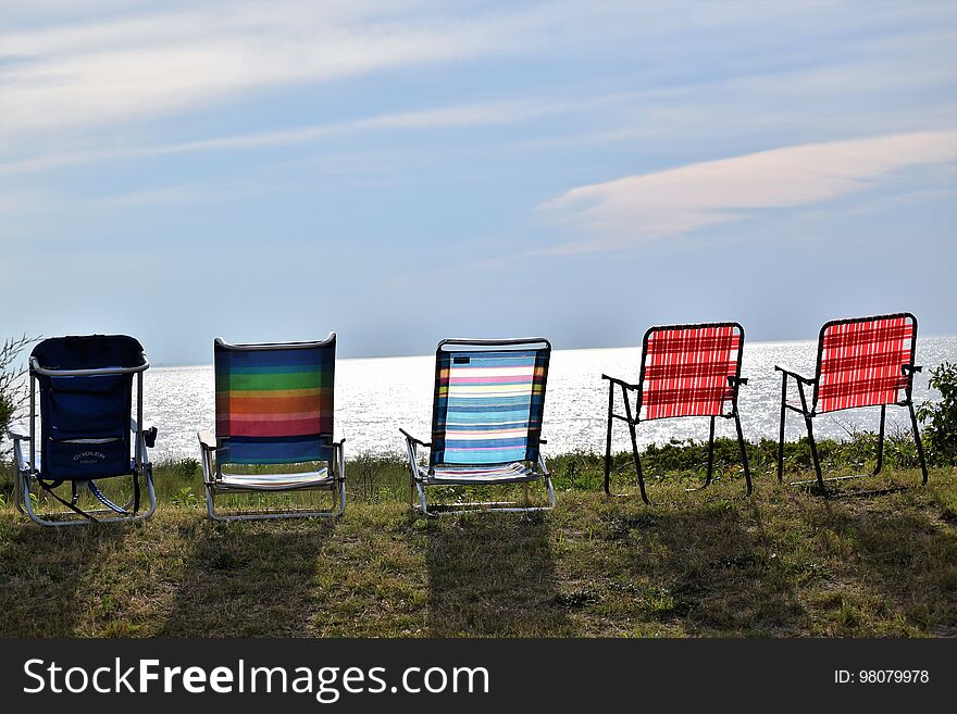 Beach chairs lined up along the bay on a hot summer day. Beach chairs lined up along the bay on a hot summer day