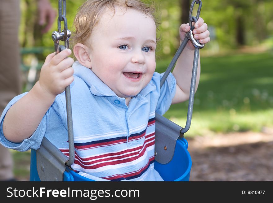 Cute Smiling Caucasion Toddler Boy on a Baby Swing. Cute Smiling Caucasion Toddler Boy on a Baby Swing