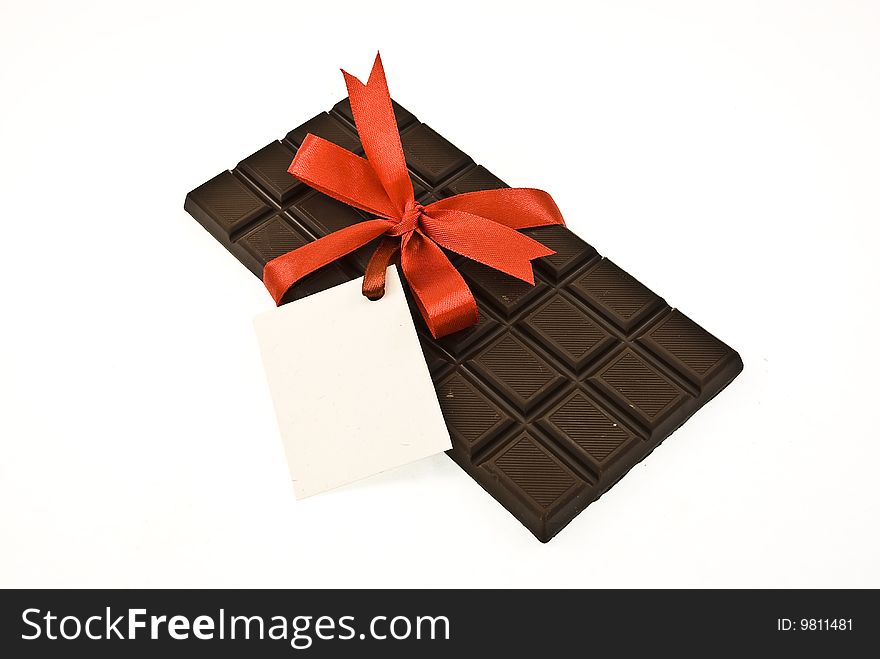 Black chocolate with red ribbon and card isolated on white