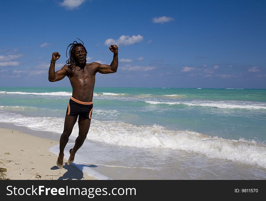 Black man jumping on the beach over blue sea and blue sky. Black man jumping on the beach over blue sea and blue sky