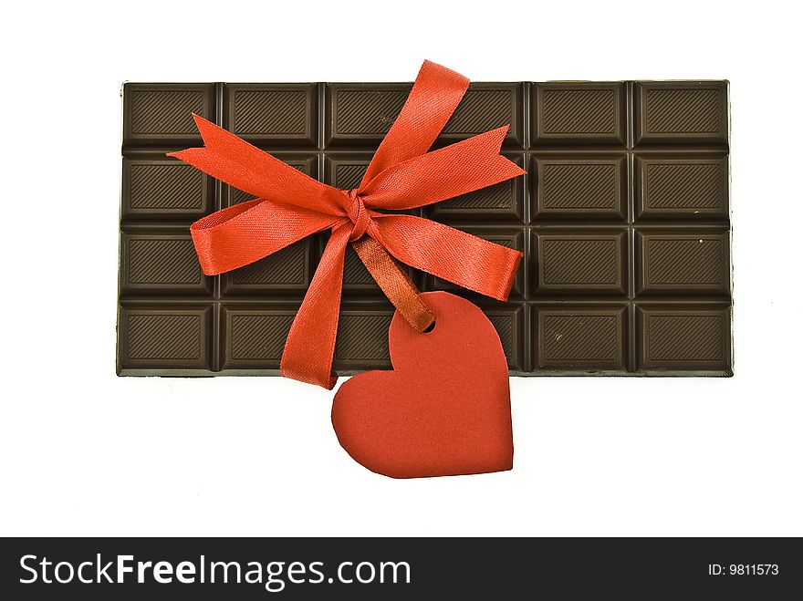 Black chocolate with red ribbon and tag heart on white