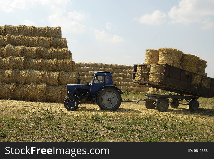 Tractor with trailer loaded with straw sheaves