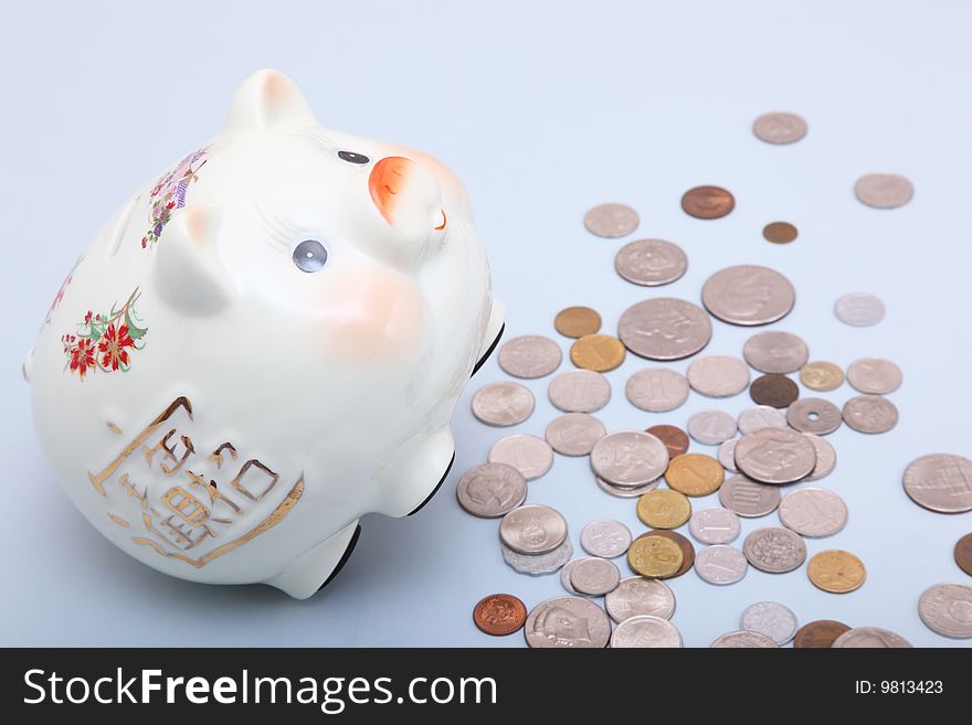 Piggy bank with coins on a light blue background