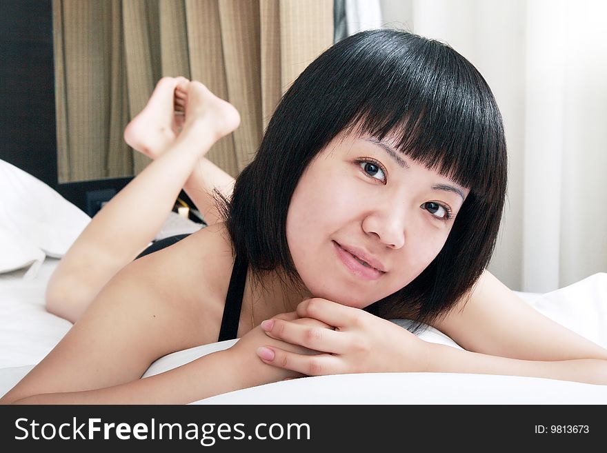 A beautiful Asian girl relaxing on the bed. A beautiful Asian girl relaxing on the bed.