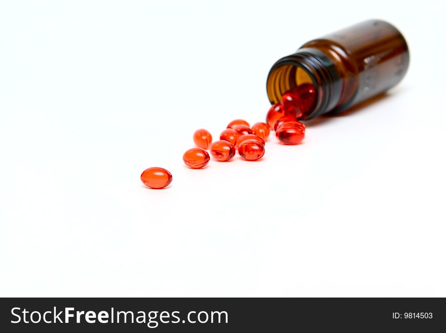 Glass Small bottle with medicine capsules isolated on white