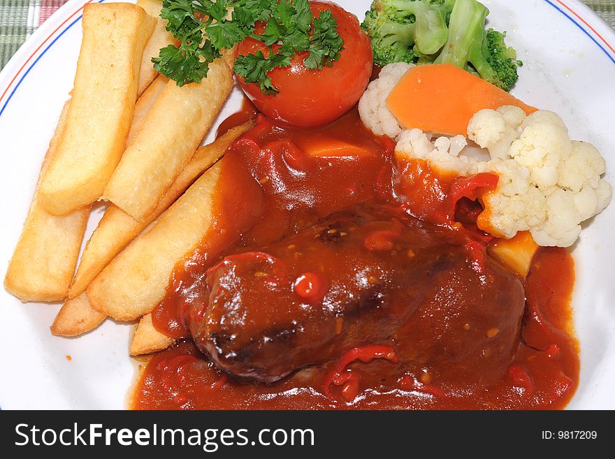 Bombay steak with fresh vegetables and french fries