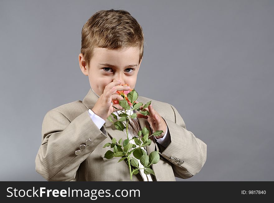 Little boy smelling orange flower and expressing his love