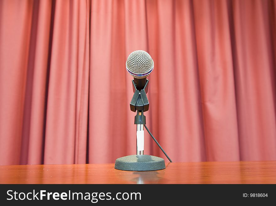 Photograph of microphone in front of a red curtain. Photograph of microphone in front of a red curtain