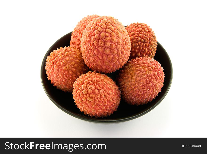 Group of lychee in a black dish with clipping and a white background