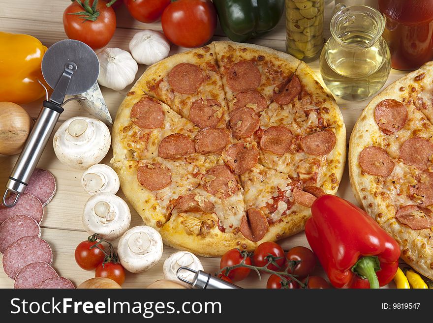 A couple of delicious pizzas, with raw tomatoes, green peppers and salami. A couple of delicious pizzas, with raw tomatoes, green peppers and salami