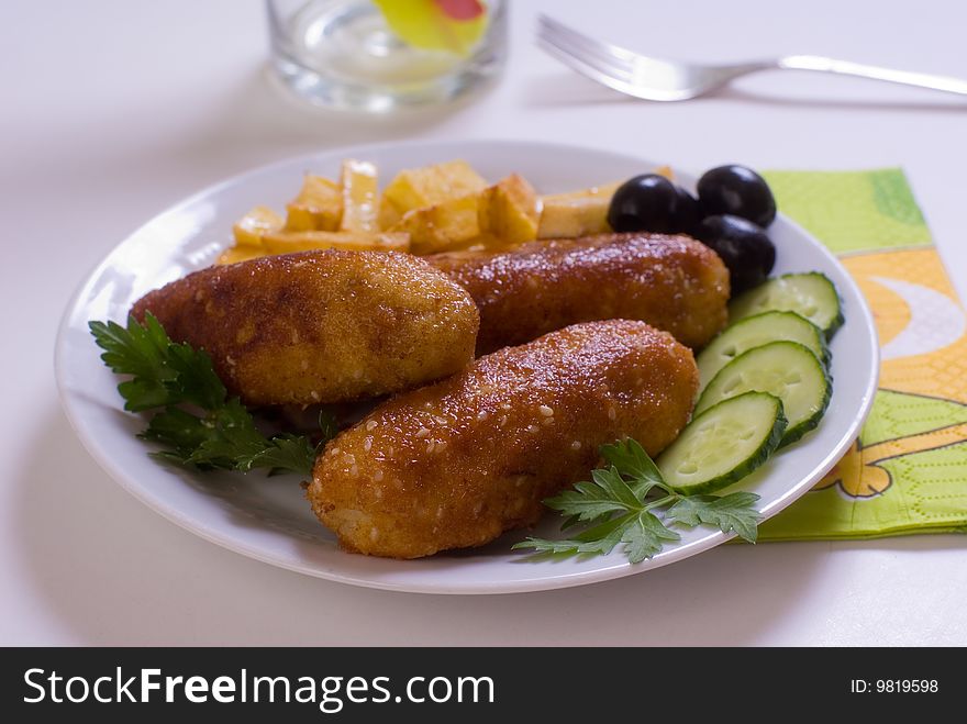 Chicken cutlet with French fries, decorated with green and black olives. Chicken cutlet with French fries, decorated with green and black olives