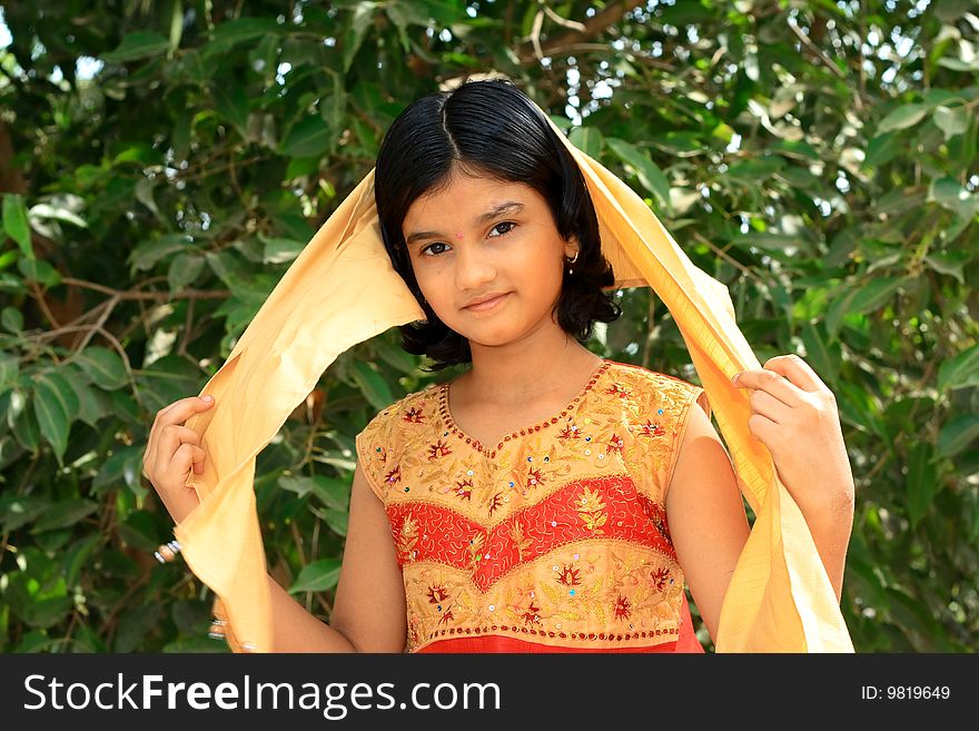 A sweet Indian girl with her bright and happy mood with beautiful ethnic dress. A sweet Indian girl with her bright and happy mood with beautiful ethnic dress.