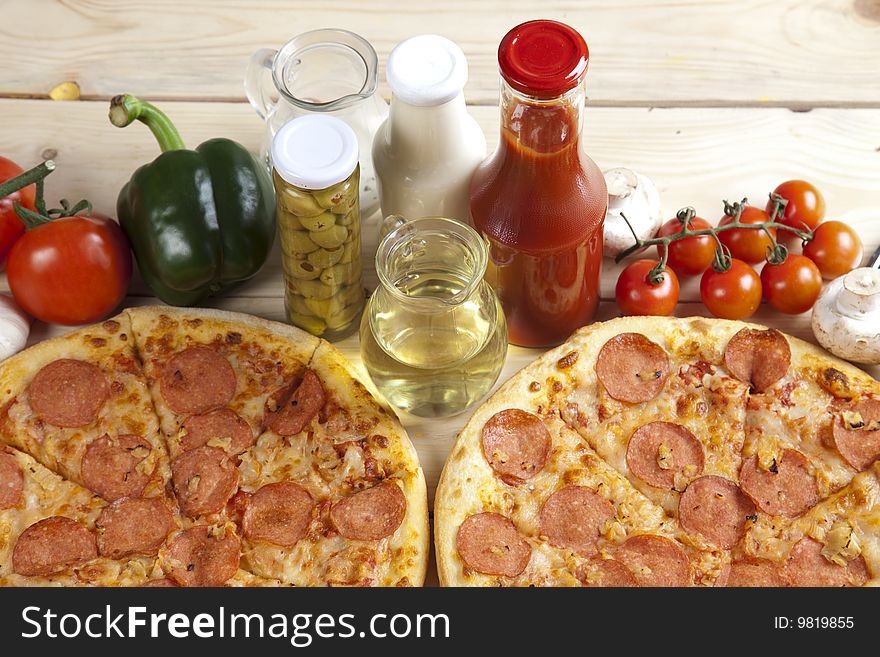 A couple of delicious pizzas, with raw tomatoes, green peppers and salami. A couple of delicious pizzas, with raw tomatoes, green peppers and salami