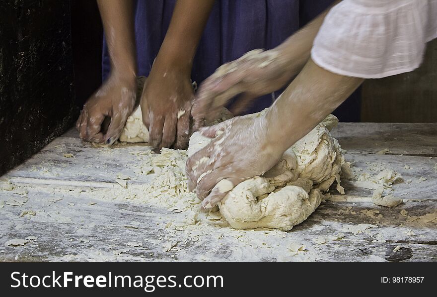 Bakers kneading bread dough in traditional way, artisan work detail, daily meal, healthy living. Bakers kneading bread dough in traditional way, artisan work detail, daily meal, healthy living