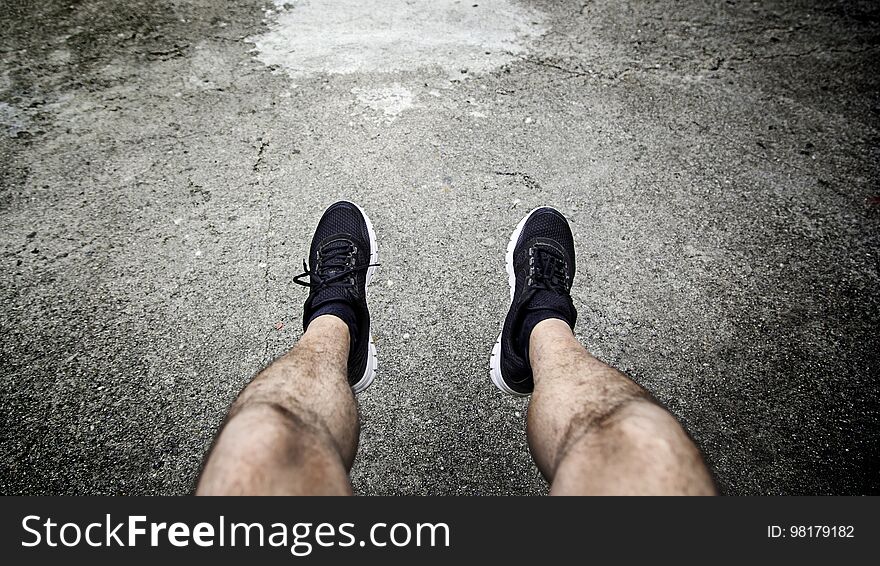 Legs of a man resting in the city, detail of a moment of relax and rest