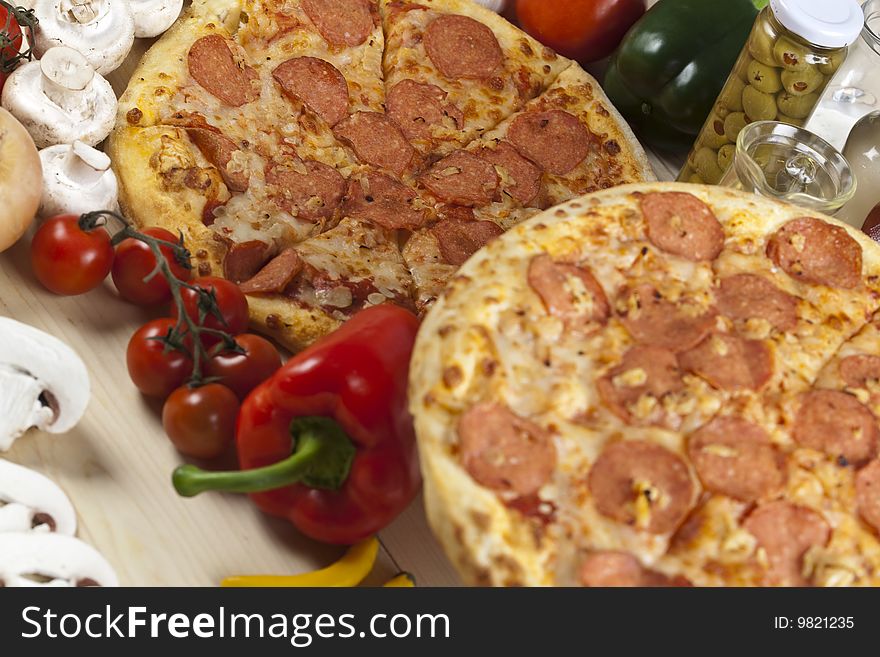 A couple of delicious pizzas, with raw tomatoes, green peppers and salami. A couple of delicious pizzas, with raw tomatoes, green peppers and salami