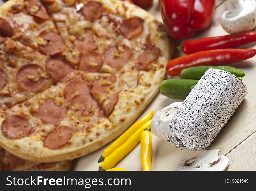 A couple of delicious pizzas, with raw tomatoes, green peppers and salami. A couple of delicious pizzas, with raw tomatoes, green peppers and salami