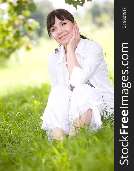 Attractive brunette woman relaxing on grass. Attractive brunette woman relaxing on grass