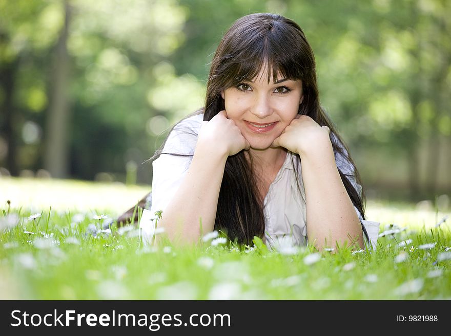 Attractive brunette woman relaxing on grass. Attractive brunette woman relaxing on grass
