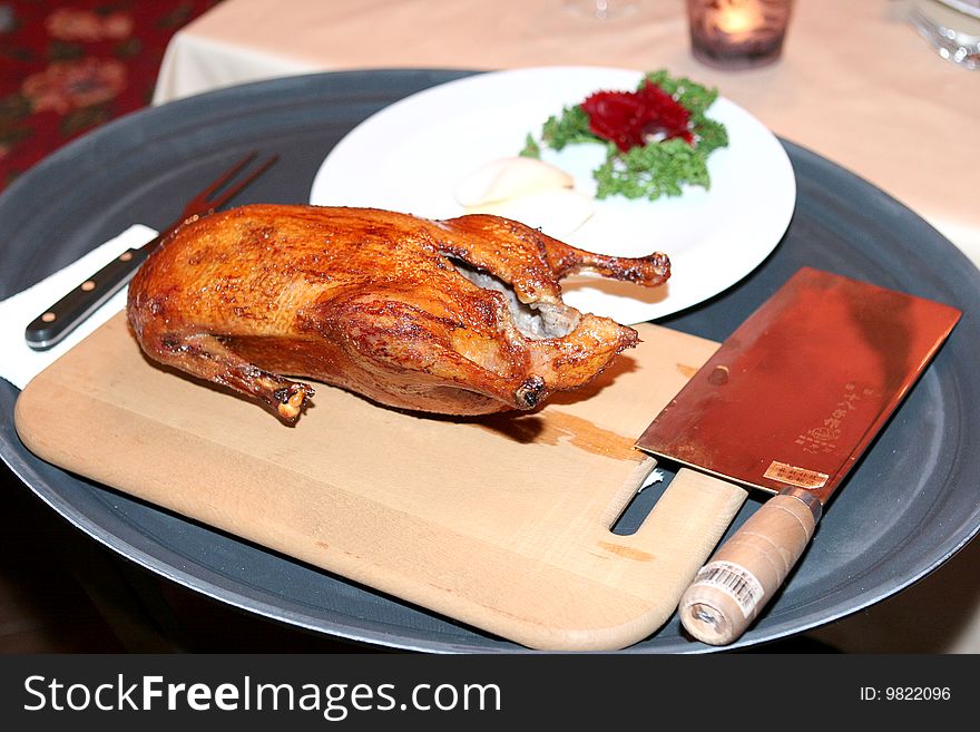 Duck on a wooden cutting board with a sharp cleaver. Duck on a wooden cutting board with a sharp cleaver.