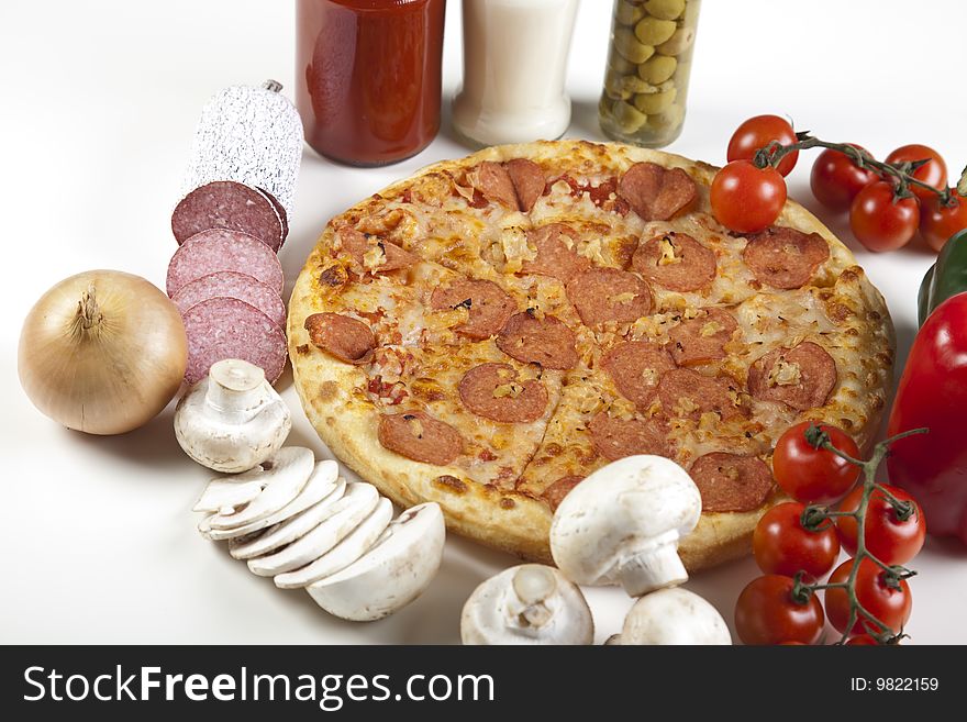 A couple of delicious pizzas, with raw tomatoes, green peppers and salami. A couple of delicious pizzas, with raw tomatoes, green peppers and salami