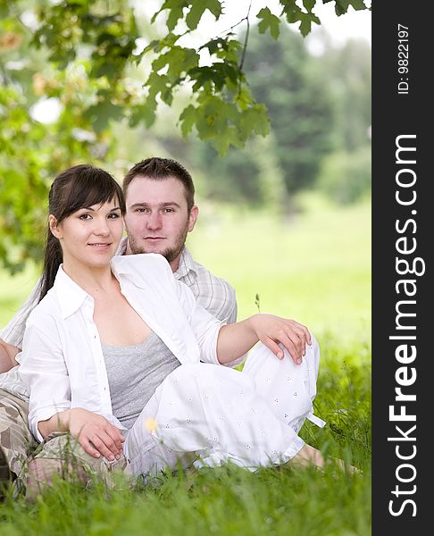Happy couple together sitting on grass. Happy couple together sitting on grass