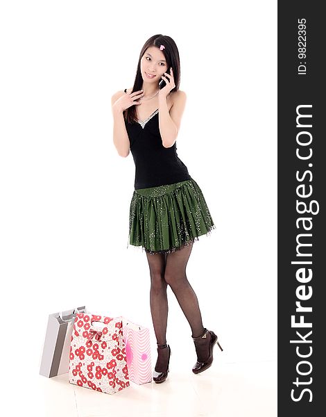 A beautiful Asian girl holds a shopping bag on white background. A beautiful Asian girl holds a shopping bag on white background.