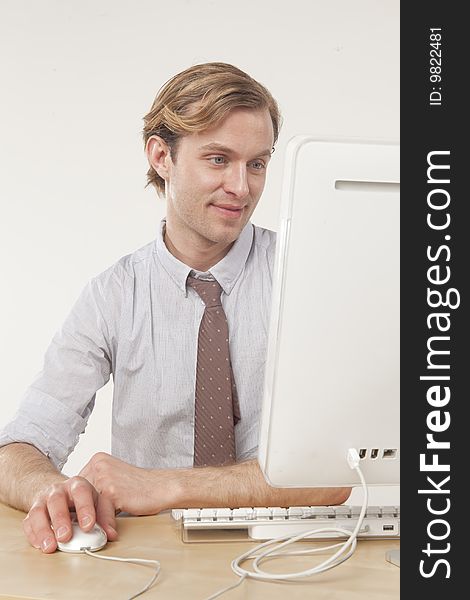 Professional man sitting at computer with pleasant expression. Professional man sitting at computer with pleasant expression