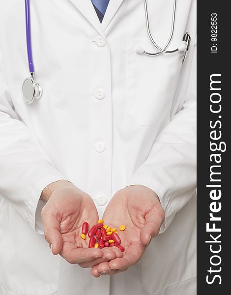 Medical professional holding red and yellow pills. Medical professional holding red and yellow pills